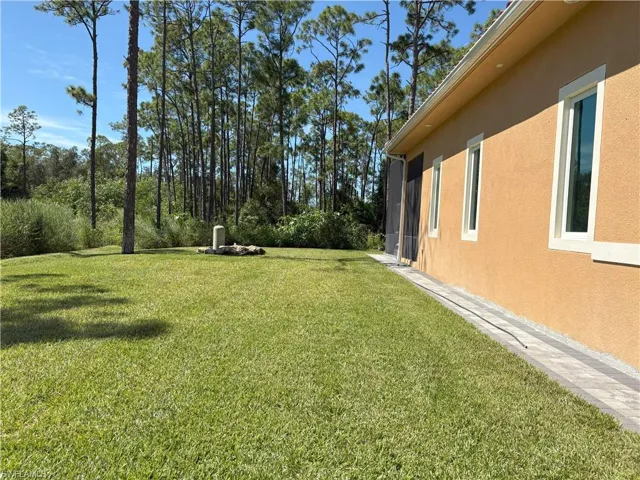 View of grassy yard with a sunroom