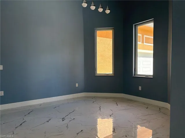 Spare room featuring baseboards and marble finish floors