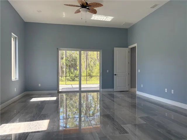 Empty room featuring a ceiling fan and baseboards