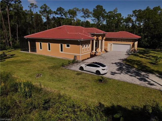 Mediterranean / spanish-style house with a tiled roof, a front yard, driveway, stucco siding, and an attached garage