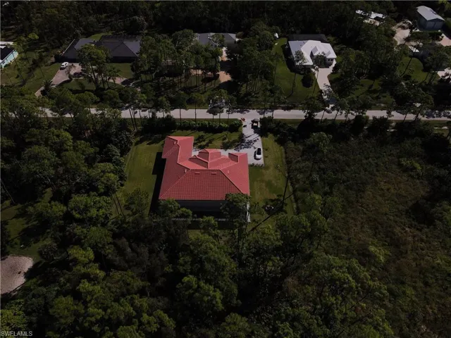 Aerial view of property and surrounding area featuring a forest
