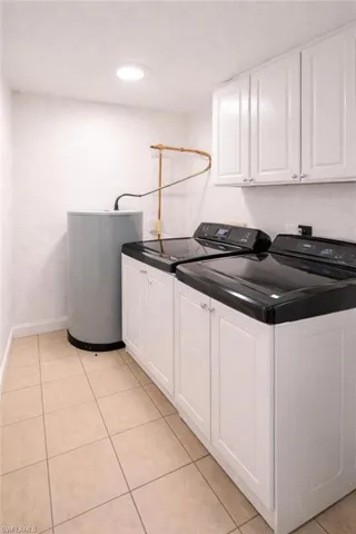 Dedicated utility area featuring a water heater, recessed ceiling lighting, and tile flooring