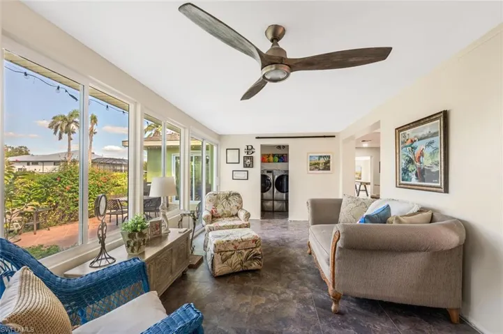 Living room featuring washing machine and clothes dryer and ceiling fan