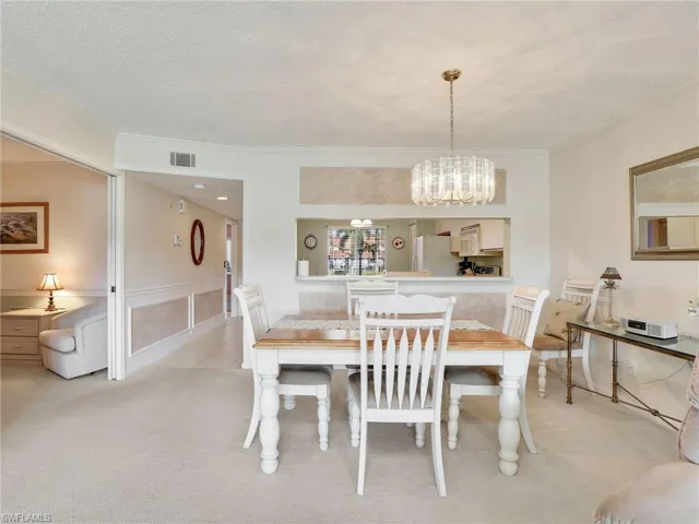 Dining area with kitchen behind and doorway to the den
