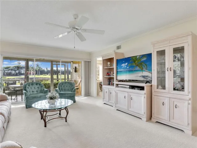 Living area with sliders to the lanai and doorway to the primary bedroom