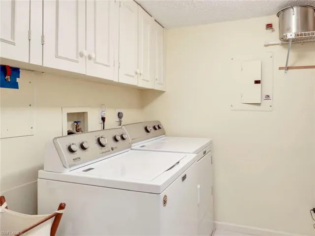 Laundry room with newer washer & dryer and cabinets