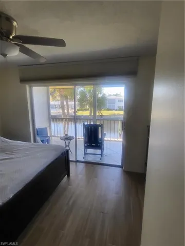 Bedroom featuring access to exterior, wood-style tile flooring, and a ceiling fan