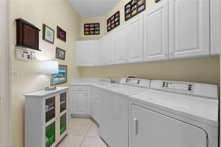 Laundry area featuring cabinets, washer and clothes dryer, and sink