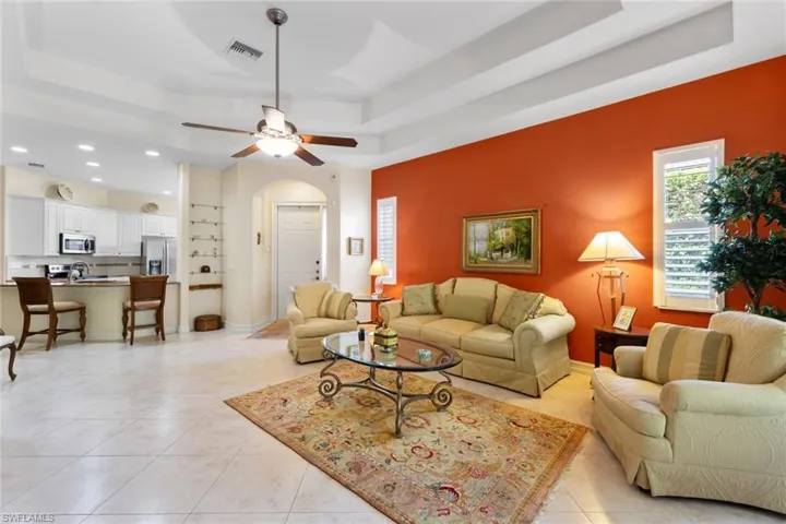 Large open great room with large neutral tile flooring and high ceilngs