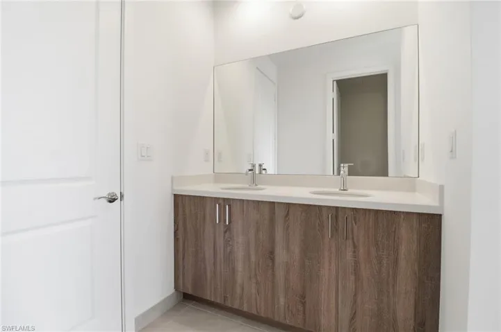Unfurnished bedroom featuring light wood-style floors, a walk in closet, and connected bathroom