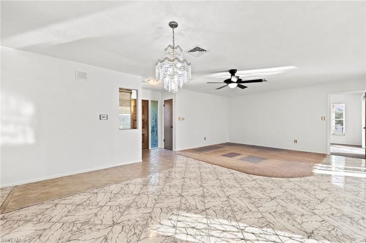 Living & Dining rooms.Nice elegant chandelier. Front entranceway with vertical window & closet.