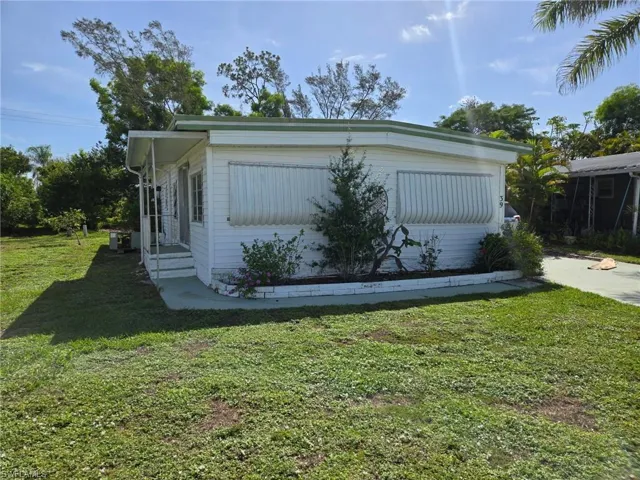 View of side of property with a lawn and entry steps