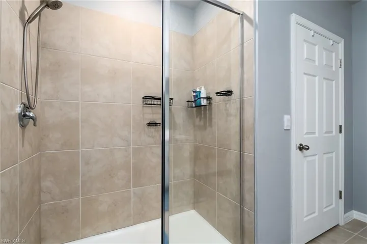 Bathroom with tiled shower and enclosure