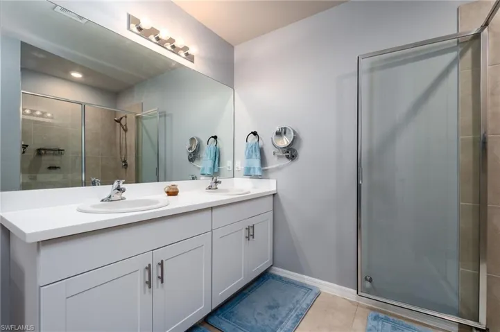 Dual sinks with Quartz Counters, large mirror and tile flooring