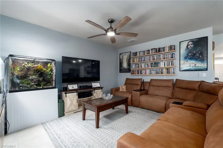 Living room with ceiling fan and light tile patterned floors