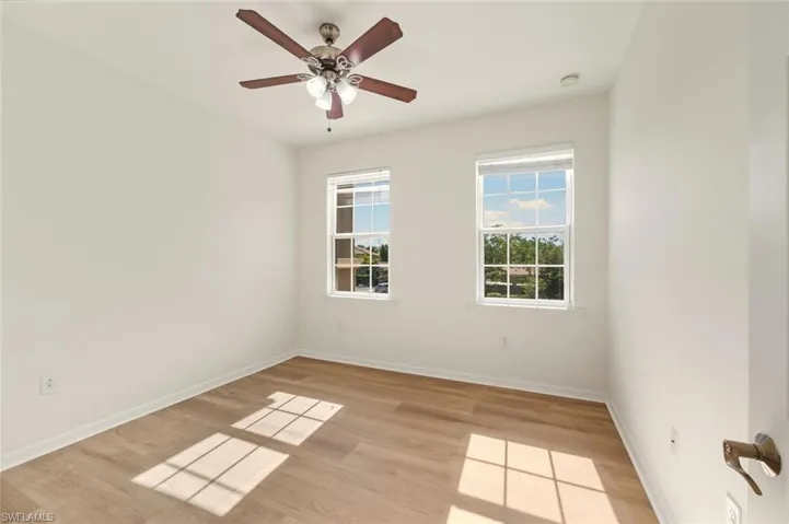 Empty room with a ceiling fan and light wood finished floors
