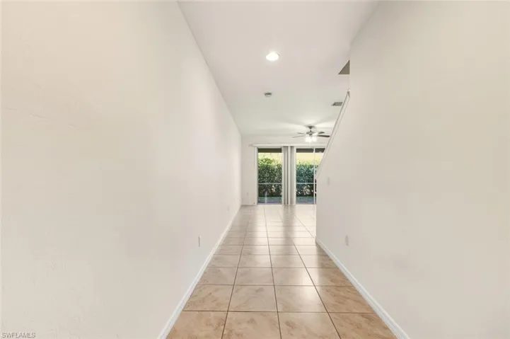 Corridor with light tile patterned floors and recessed lighting
