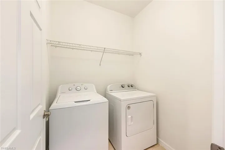 Washroom featuring washer and dryer and baseboards