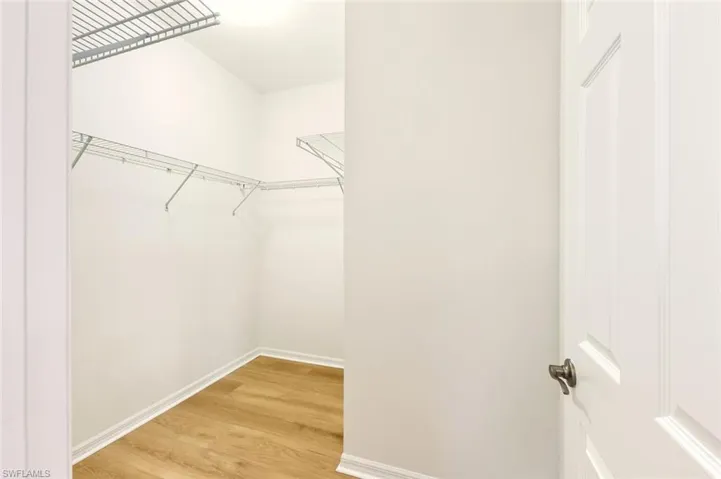 Walk in closet with light wood-style floors
