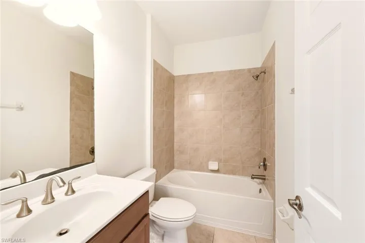 Bathroom featuring vanity, washtub / shower combination, and light tile patterned floors