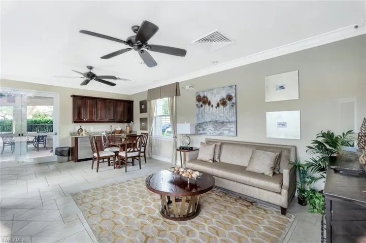 Living area featuring ornamental molding and a ceiling fan