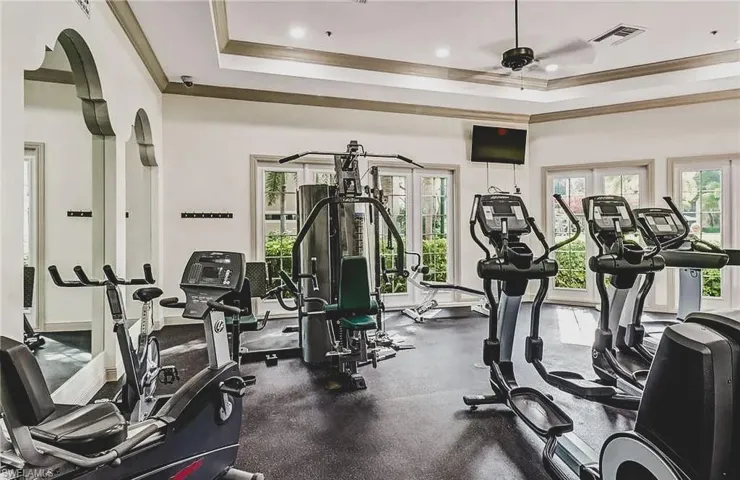 Gym with crown molding, recessed lighting, and a ceiling fan