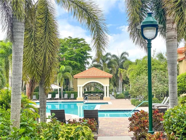 Community pool with a gazebo, a patio area, and view of scattered trees
