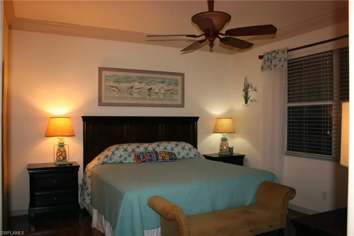 Bedroom featuring crown molding, ceiling fan, and dark wood-style floors