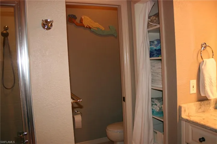 Bathroom featuring vanity, a textured wall, and a shower with shower door