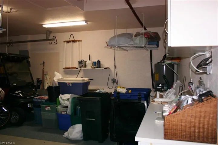 Garage with water heater and a textured wall