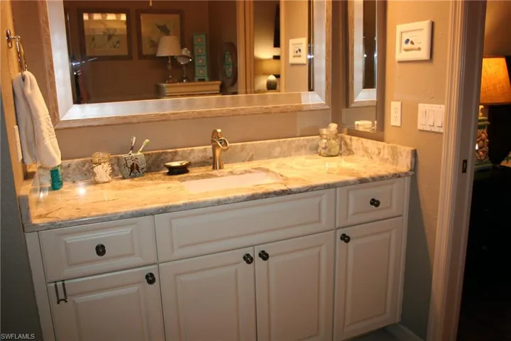 Bathroom with vanity and a textured wall