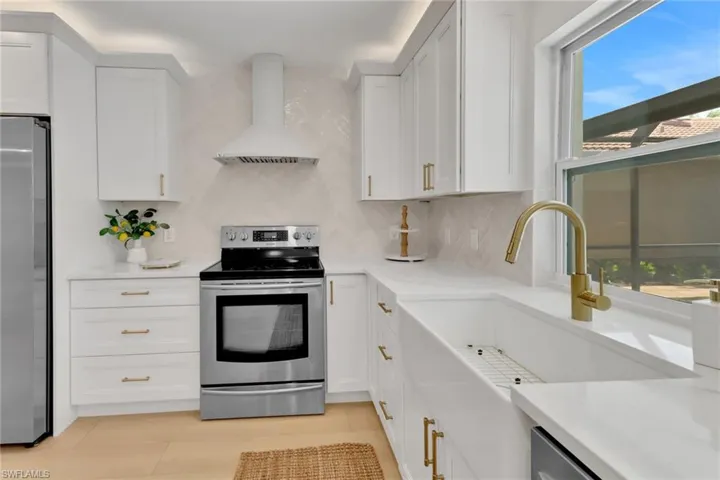 Custom range hood, farmhouse sink overlooking pool