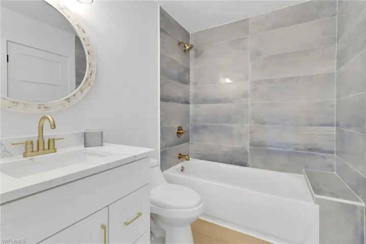Full bathroom upstairs with tiled shower / bath, toilet, and vanity