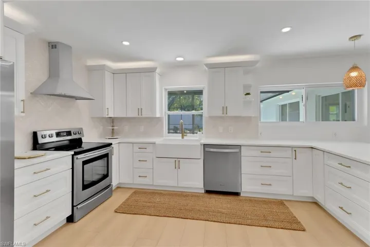 Expansive Kitchen with farmhouse sink, and complimentary herringbone style backsplash.