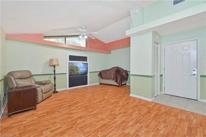 Living area featuring vaulted ceiling, ceiling fan, and light hardwood / wood-style flooring
