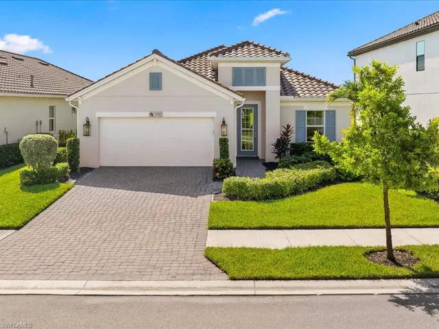 Coastal Elevation  with stucco siding, decorative driveway, an attached garage, and a front lawn