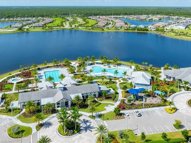 Aerial view of residential area featuring a nearby body of water and a pool