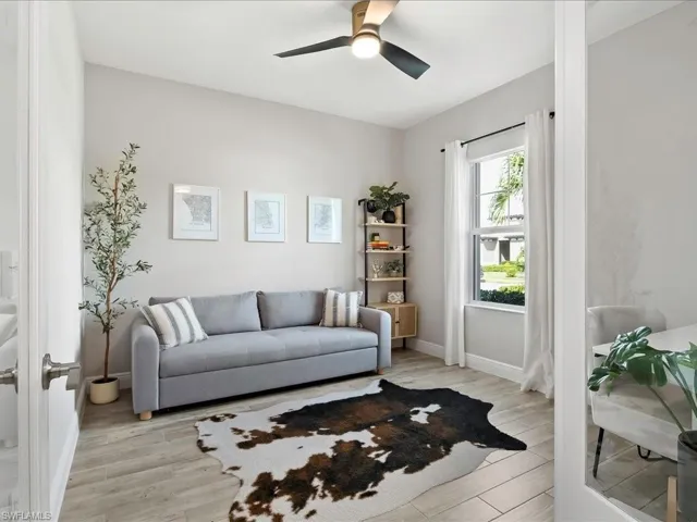Den featuring light wood-type flooring and ceiling fan, glass double doors