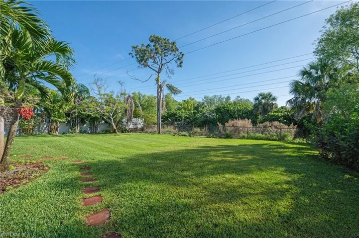 A large fenced in backyard has plenty of room for dogs, barbecues and more.