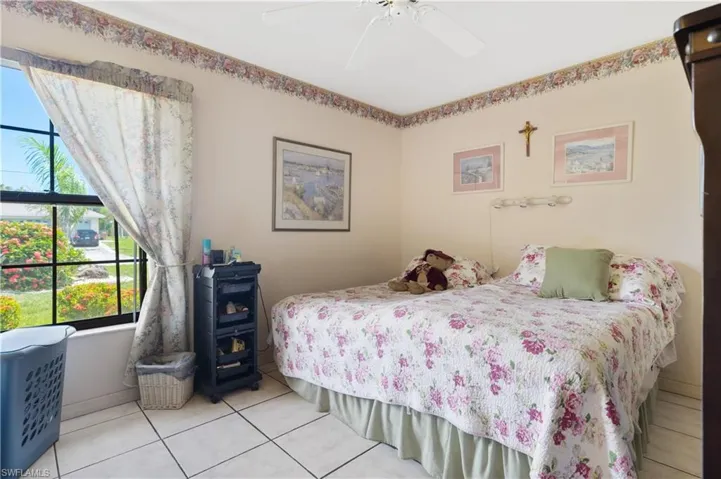 Bedroom featuring multiple windows, tile patterned floors, and ceiling fan