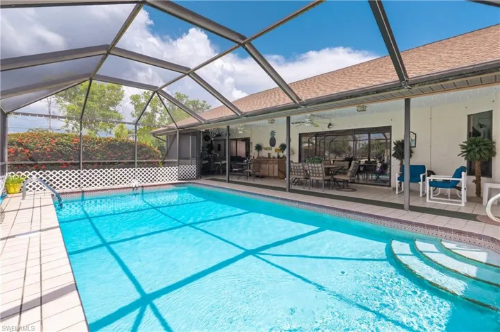 Swimming pool with ceiling fan, a patio, and glass enclosure