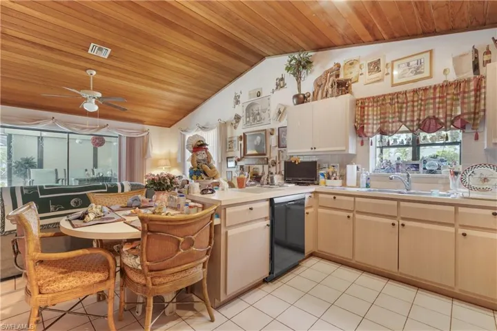 Kitchen with wood ceiling, black dishwasher, light countertops, ceiling fan, and lofted ceiling