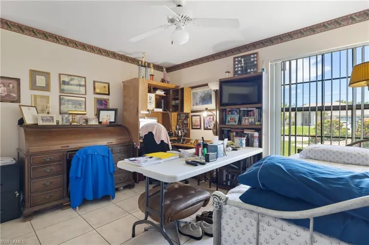 Home office featuring light tile patterned flooring and a ceiling fan