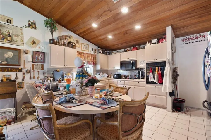 Dining space with light tile patterned floors, vaulted ceiling, wood ceiling, and recessed lighting