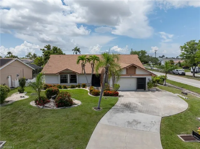 Ranch-style house featuring driveway, stucco siding, a garage, and a front lawn