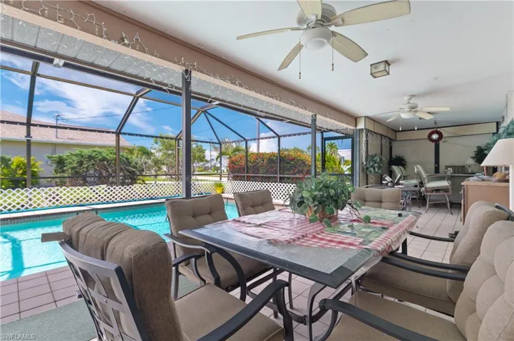 View of patio / terrace featuring outdoor dining area, ceiling fan, an outdoor pool, and a lanai