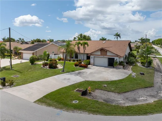 Single story home featuring stucco siding, driveway, a front yard, and a garage