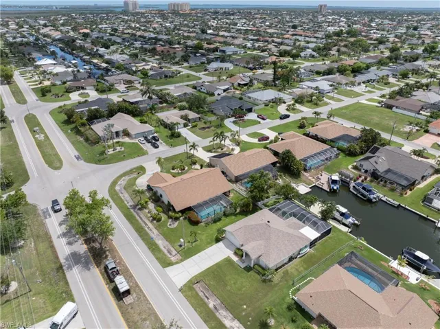 Aerial view of property and surrounding area featuring a large body of water and nearby suburban area