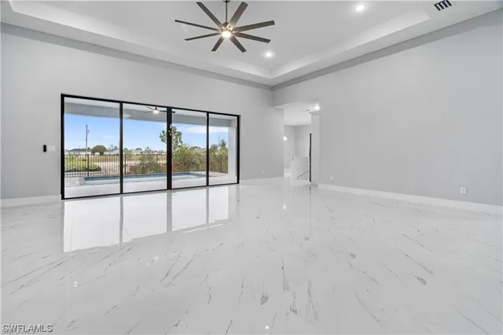 Spare room featuring ceiling fan and a raised ceiling