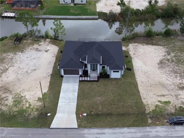 Birds eye view of property with a water view